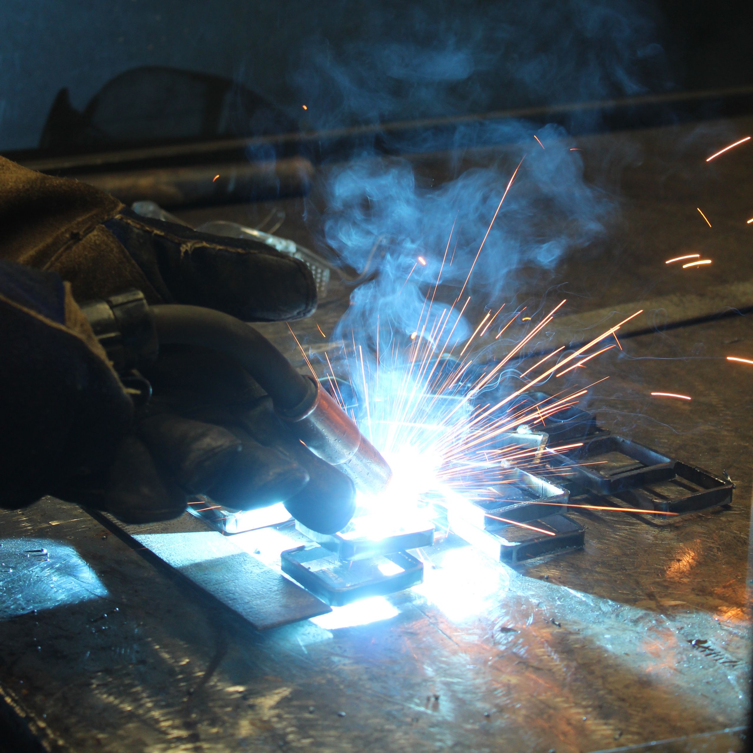 A welder welding in protective clothing and helmet